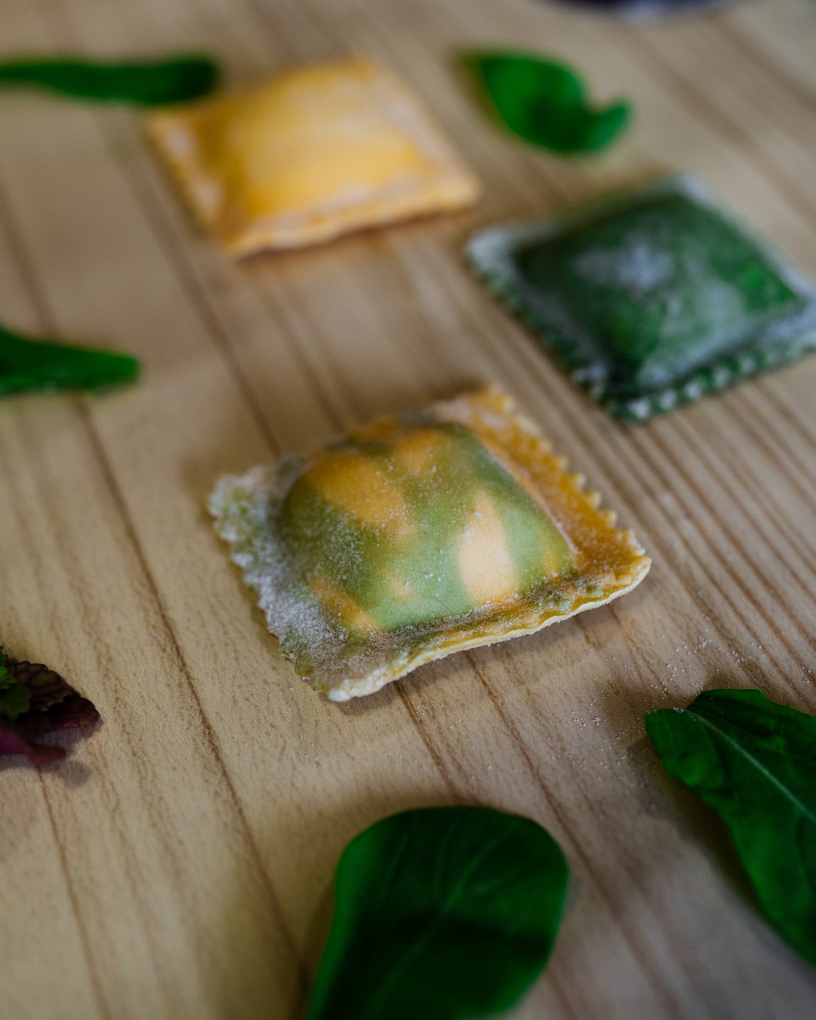 Raviolón de masa marmolada apoyado sobre una tabla de madera
